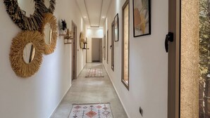 A hallway with wall-mounted mirrors, framed artwork, and a patterned carpet. - Villa Tilelli - Pool & Quiet - 15 minutes from Essaouira (Essaouira)