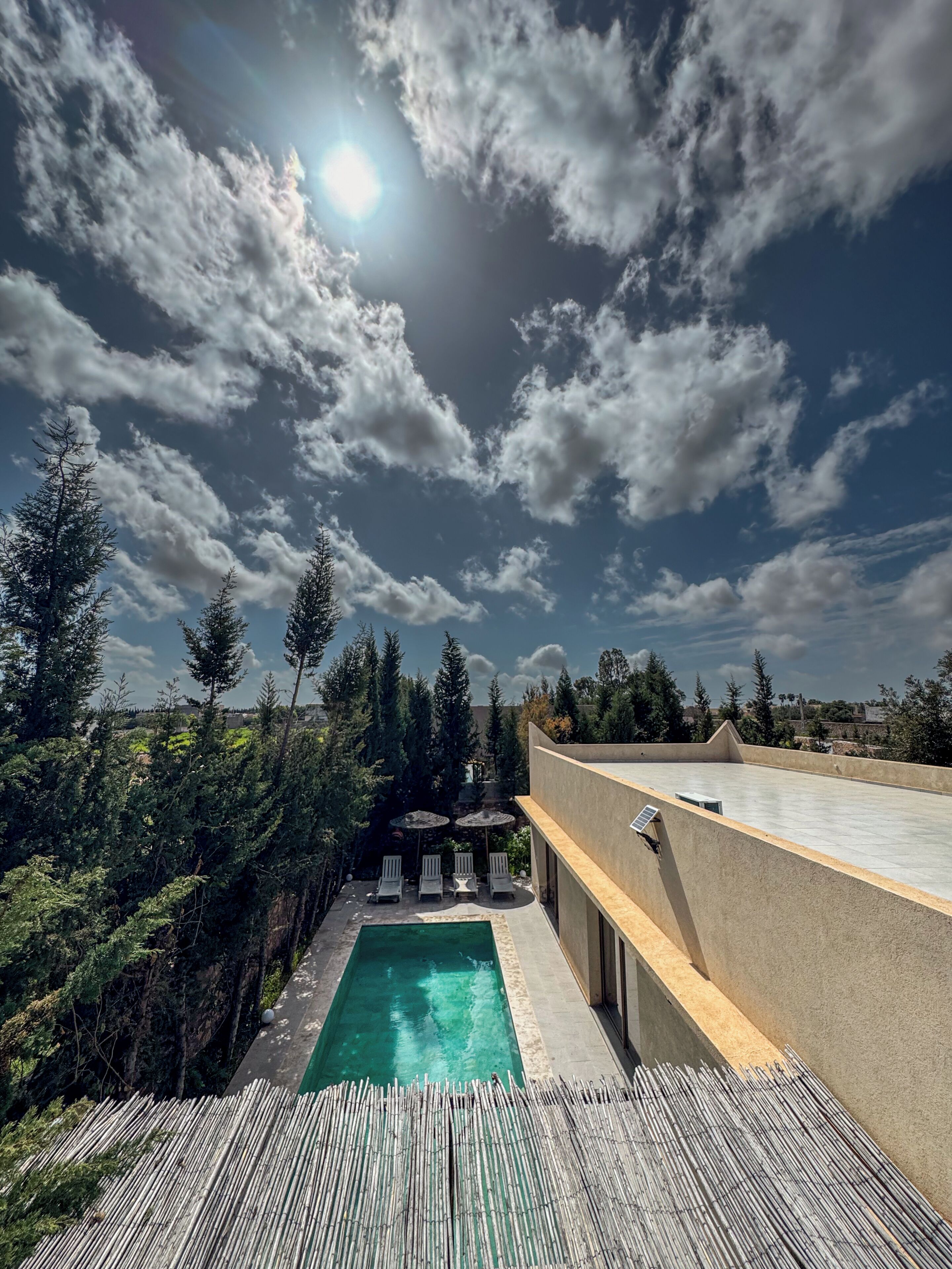 Une piscine sur le toit offrant une vue dégagée sur le ciel et les arbres environnants.
