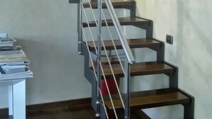 A staircase with metal railings and wooden steps, leading to an upper floor.