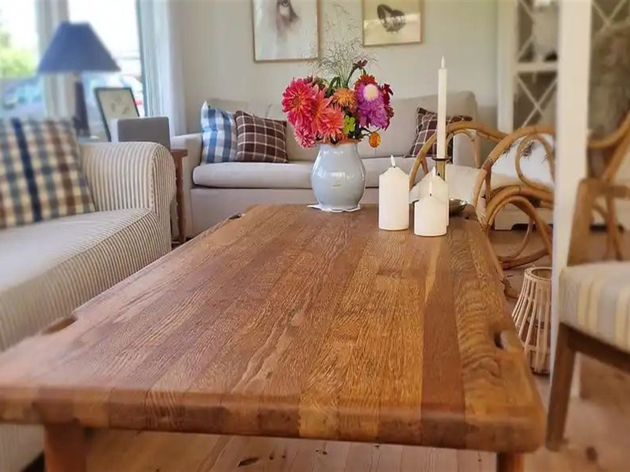 Ein Holztisch mit einer Blumenvase, einem Kerzenständer und einer Kerze.