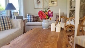 Ein Holztisch mit einer Blumenvase, einem Kerzenständer und einer Kerze.