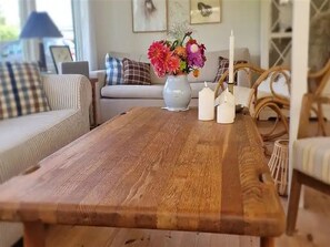A wooden table with a vase of flowers, a candle holder, and a candle. - "Benja" -  from the sea by Interhome (Hals)