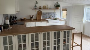 Eine Küche mit Holztischplatte, weißen Schränken und einem Fenster mit Blick.