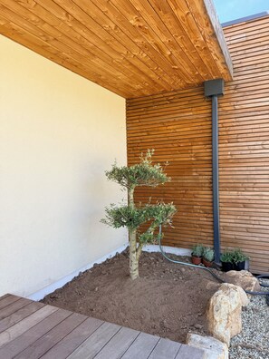 A wooden deck, a small tree, and a wooden wall. - New villa with pool (Ghisonaccia)