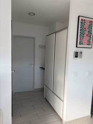A room with a sliding door, a wall-mounted light switch, and a framed floral artwork. - Comfortable modern house in Pelissanne (Pélissanne)