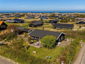 Ein Wohngebiet mit Häusern, einer asphaltierten Straße und Blick auf das Meer.