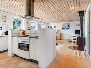 Eine moderne Küche mit Kochinsel, Herd und großem Fenster.