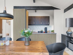 A modern kitchen with dark wooden cabinets, a marble countertop, and a black pendant light. - "Gojko" -  from the sea by Interhome (Hals)