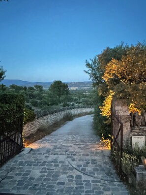 A stone pathway leading to a gate with a view of a landscape and distant hills. - Luxury and serenity, large private estate in Gordes. 5 air-conditioned rooms, (Gordes)