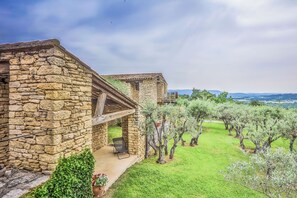 Un edificio in pietra con un balcone che si affaccia su una vigna.