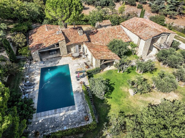 An aerial view of a property with a swimming pool, stone buildings, and surrounding greenery. - Luxury and serenity, large private estate in Gordes. 5 air-conditioned rooms, (Gordes)