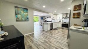 A modern kitchen with white cabinets, a central island, and a built-in oven. - Lake house with kayaks, fishing & heated community pool (Holiday)