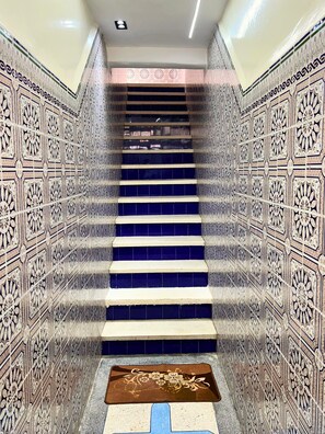 A staircase with intricate tile patterns on the walls and a blue-tiled floor. - Private Full Home in Agadir - Families & Groups (Agadir)