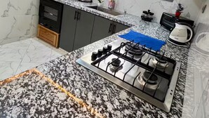 A kitchen with a gas stove, a microwave, and a coffee maker.