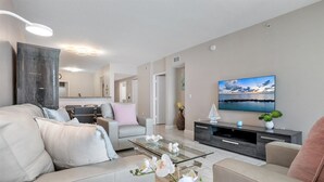 A modern living room with a sofa, coffee table, and TV. - Spectacular Water Views 2br-4 beds in Sunny Isles Beach (Sunny Isles Beach)