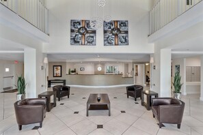 A spacious lobby with a reception desk, seating area, and artwork on the walls. - Spectacular Water Views 2br-4 beds in Sunny Isles Beach (Sunny Isles Beach)
