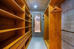 A narrow walk-through closet with wooden shelving and a hanging rod. - Private Vacation Home in Tamarindo! Sleeps 6 (Tamarindo)