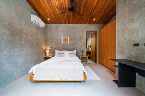 A modern bedroom with a wooden ceiling, a large bed, bedside tables, a wardrobe, and a TV stand. - Private Vacation Home in Tamarindo! Sleeps 6 (Tamarindo)