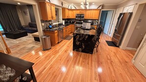 A modern kitchen with wooden cabinets, a central island, and a stainless steel refrigerator.
