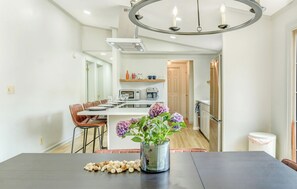 A modern kitchen with a central island, a dining area with a table and chairs, and a chandelier. - Gorgeous 3-bedroom house with AC near Lake Norman of Catawba (Lake Norman of Catawba)