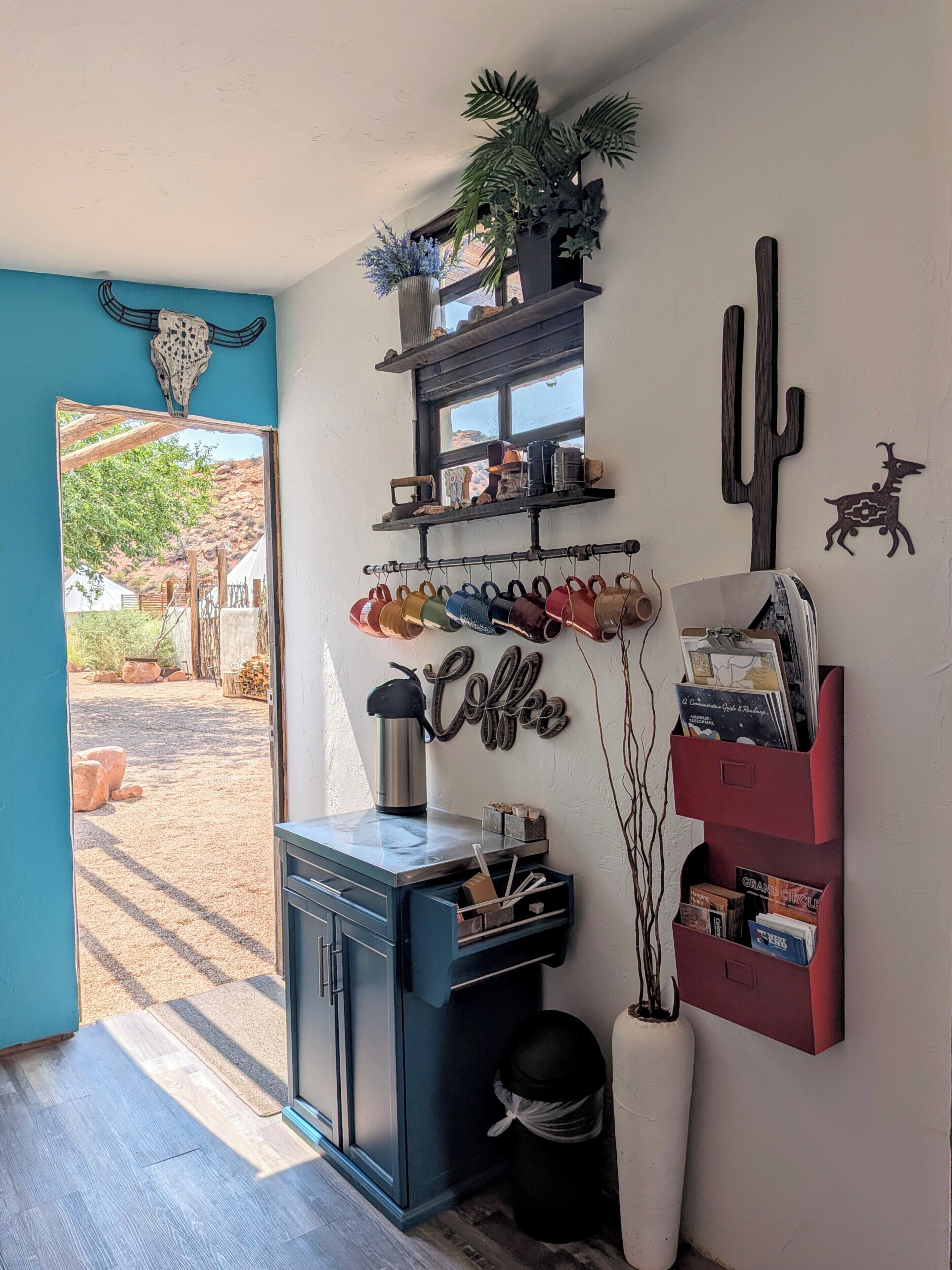 A room with a coffee station, a cactus decoration, and a window with a view of an outdoor area.