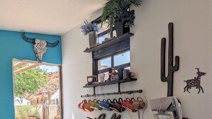 Una habitación con estación de café, decoración de cactus y ventana con vista a un espacio exterior.