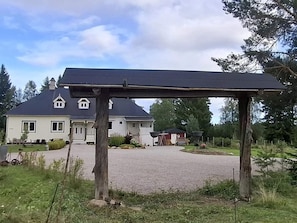 A house with a covered porch, a driveway, and a well-maintained lawn. - 5 Star Holiday Home in Skattungbyn Orsa (Orsa)