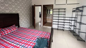 Ein Schlafzimmer mit Bett, Kleiderschrank, Spiegel und Regale.