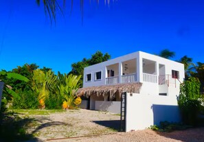 A white building with a thatched roof, a balcony, and a ladder leading to the entrance. - Top floor Oasis/Private Pool/ High-Speed WiFi (Punta Cana)