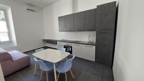 Une cuisine compacte avec un coin repas, comprenant un four encastré, un évier et un réfrigérateur.