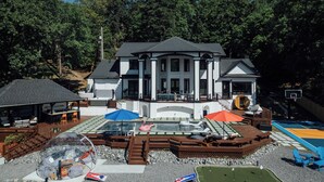 A large house with a swimming pool, outdoor seating, and a tennis court. - The Superstar | Waterfront Pool & Pickleball (Hot Springs National Park)