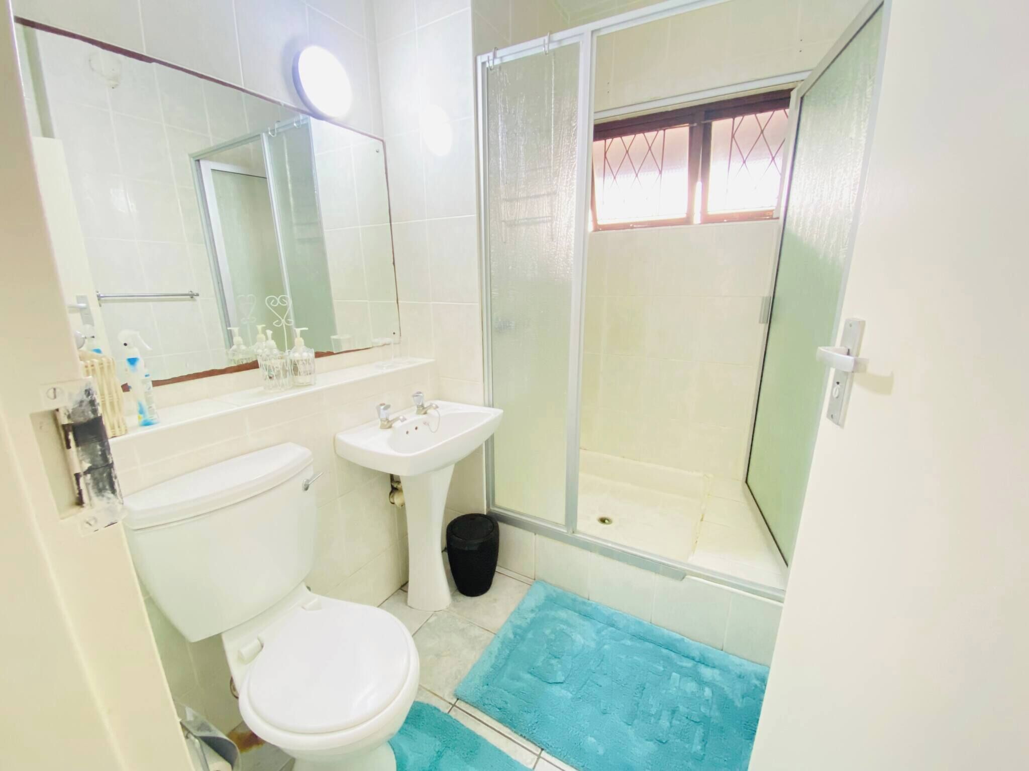 A bathroom with a toilet, sink, and shower.