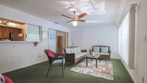 A room with a ceiling fan, a sofa, a chair, a small table, and a rug. - Cozy Private Unit w/ Shared Heated Pool (Cape Coral)