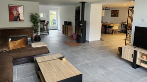 Un salon moderne comprenant un canapé, une table basse, un meuble pour la télévision et une cheminée.