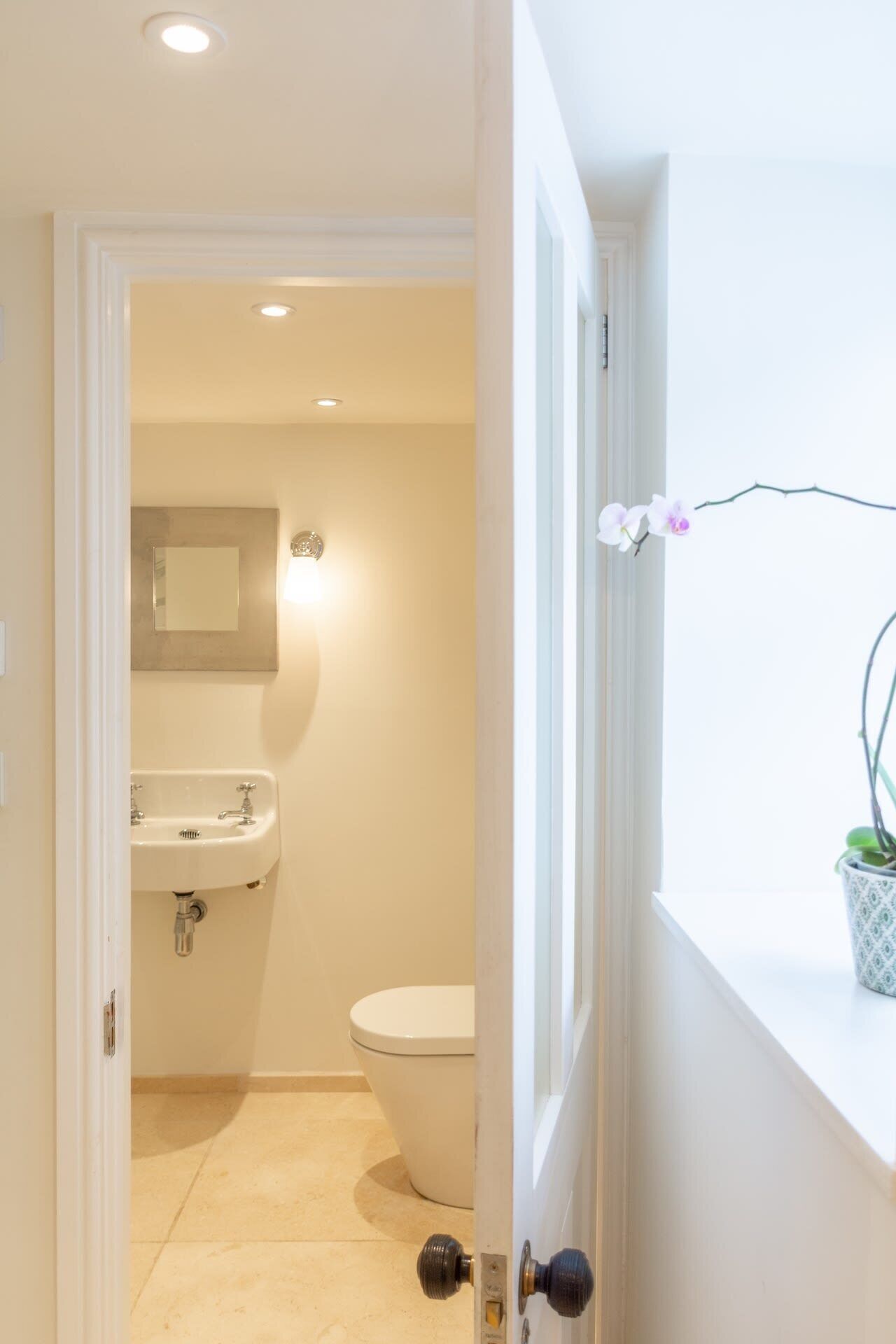 A bathroom with a toilet, sink, and mirror.