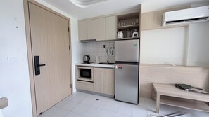 Eine kompakte Küche mit Einbauofen, Kühlschrank und Spüle.