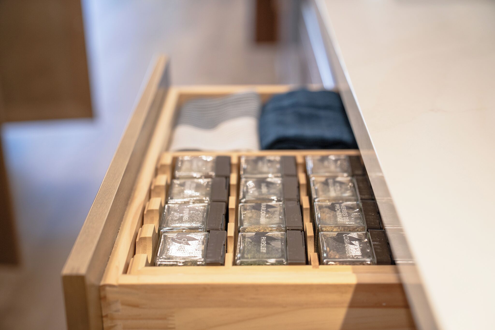 Un cajón de madera con varios compartimentos, algunos con objetos transparentes.