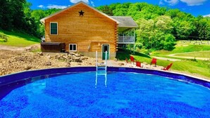 A wooden cabin with a pool, surrounded by greenery. - Wexford Hollow 6 BR Cabin with Swimming Pool & Hot Tub (Lansing)