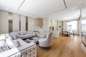A modern living room with a sofa, armchair, and coffee table. - White Escape | 3BR Luxury Lalzi Beach Villa (Gjiri i Lalzit)