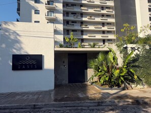 A modern building with a sign labeled 'OASIS' and a gated entrance. - Casa Camille at Oasis Rivera del Rio (Puerto Vallarta)