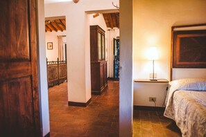 A bedroom with a bed, a nightstand, a lamp, and a wooden wardrobe. - Apartment in Castelnuovo Berardenga (Castelnuovo Berardenga)