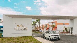 En hvid bil parkeret foran en bygning, hvor der står 'ORLANDO RESORT'.