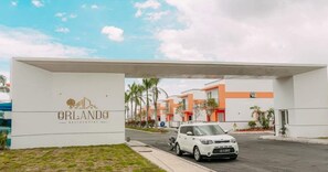 A white car parked in front of a building with a sign that reads 'ORLANDO RESORT'. - Fabulous 3 Bedroom House in a Gated Community Condominium Residential Orlando (Kilamba)