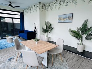 A modern dining area with a wooden table, four chairs, and potted plants. - Unbelievable Oasis with Private Pool, Spacious and Resort Home (Goodyear)