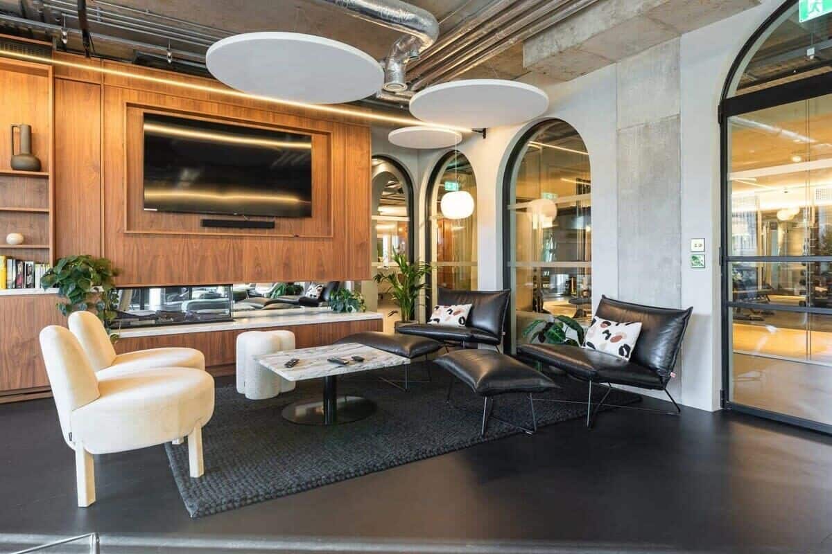 A modern lounge area with leather seating, a flat-screen TV, and a coffee table.