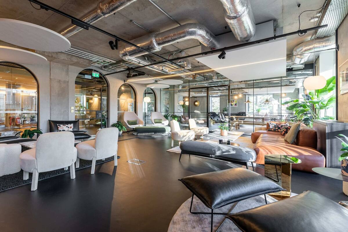 A modern lounge area with seating, a coffee table, and a sofa.