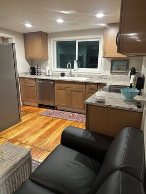 A compact kitchen with wooden cabinets, a sink, and a window above it. - Cozy 1-bedroom cabin in soothing Pollock Pines with AC (Pollock Pines)