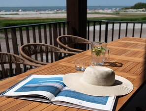 A wooden table with a book, a hat, and a pitcher of water. - Luxury Workum Waterside Stay With Sauna (Workum)