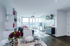 A modern living room with a dining area, large windows, and a view of the city. - Skyline 2BD/2BA Central Nottingham Free Parking (Nottingham)