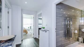 A modern bathroom with a large mirror, a towel rack, and a sink.